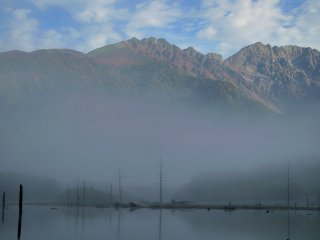 朝霧に包まれる幻想的な大正池。次第に晴れ間から焼岳が顏を覗かせる